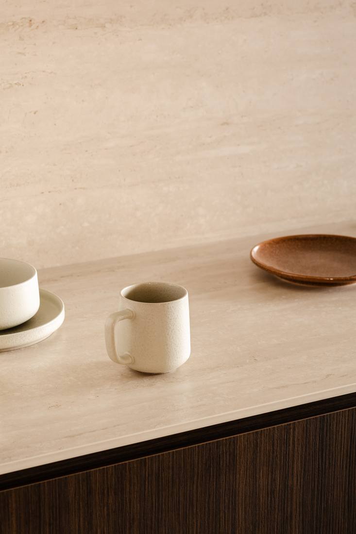 Travertine counter and timber joinery in raking light